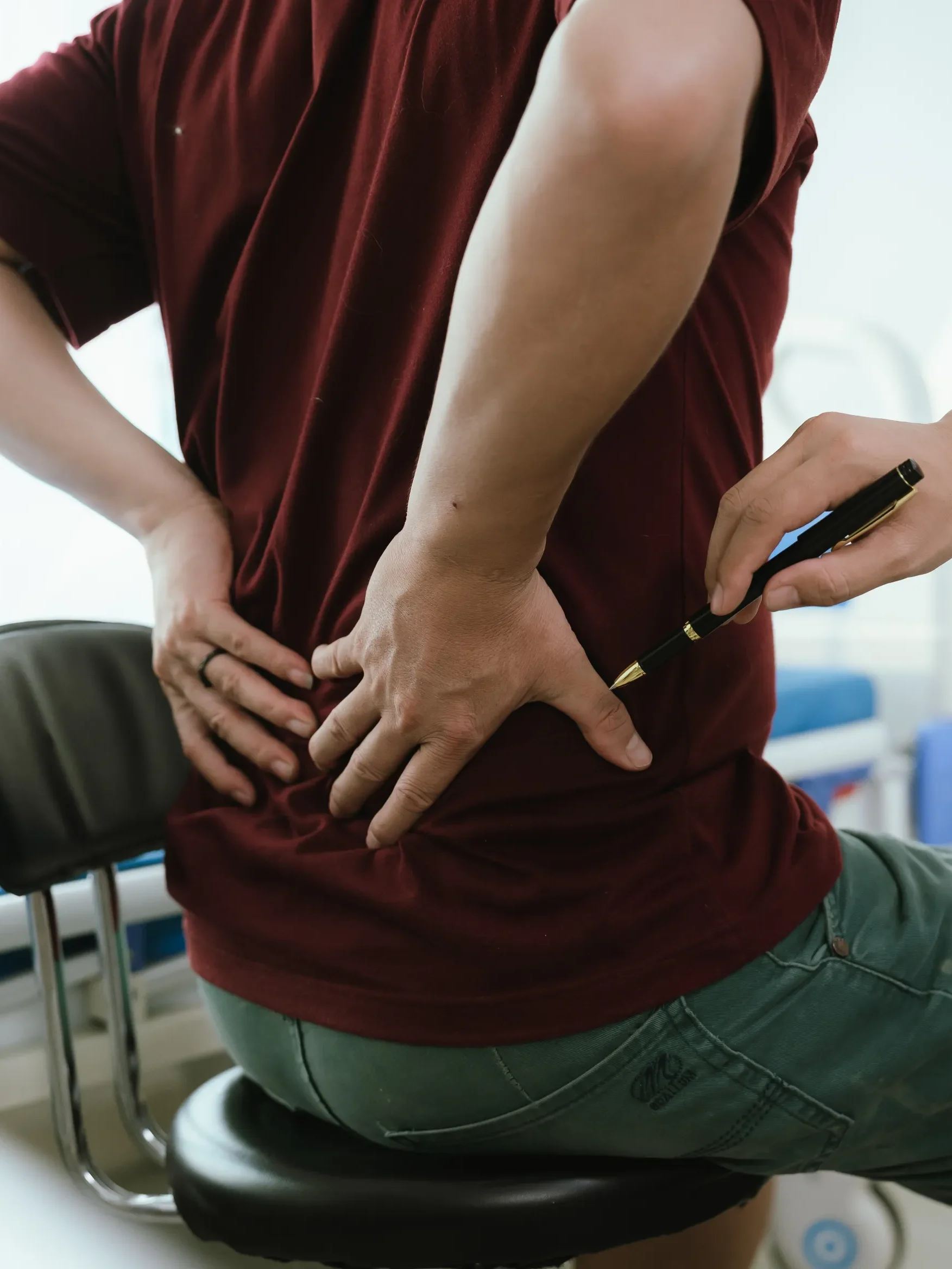 physiotherapist examining a patient's back to find the source of their back pain